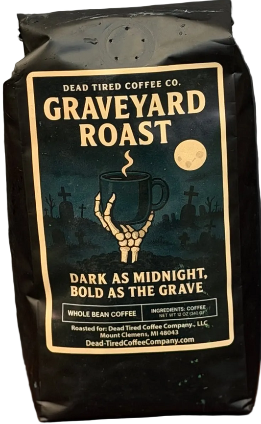 Graveyard Roast coffee bag by Dead Tired Coffee Co. Its midnight graveyard label shows a skeletal hand lifting a steaming mug beneath the moon; inside is a specialty-grade six-bean dark roast.