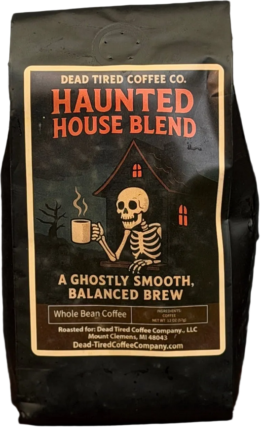 Haunted House coffee bag by Dead Tired Coffee Co. Its dark label shows a skeleton holding a steaming mug before a haunted house; inside is medium roast, single-origin Peru coffee.